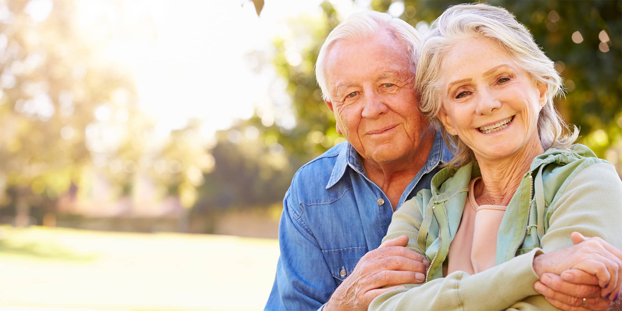 Couple embracing sitting outside on a bright and sunny day